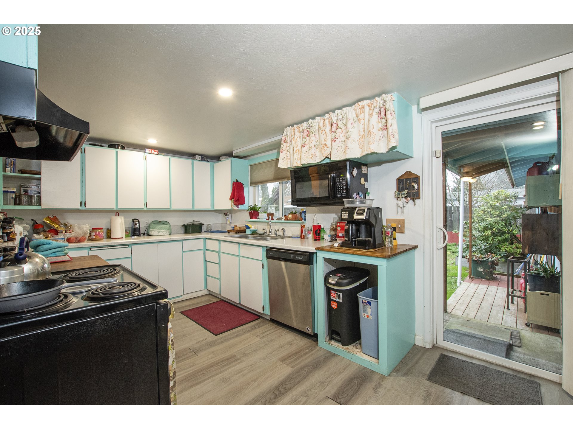 1253 30th Street Springfield, OR 97478 - Photo 6 of 15 a kitchen with stainless steel appliances granite countertop a refrigerator a sink dishwasher a stove and white countertops with wooden floor