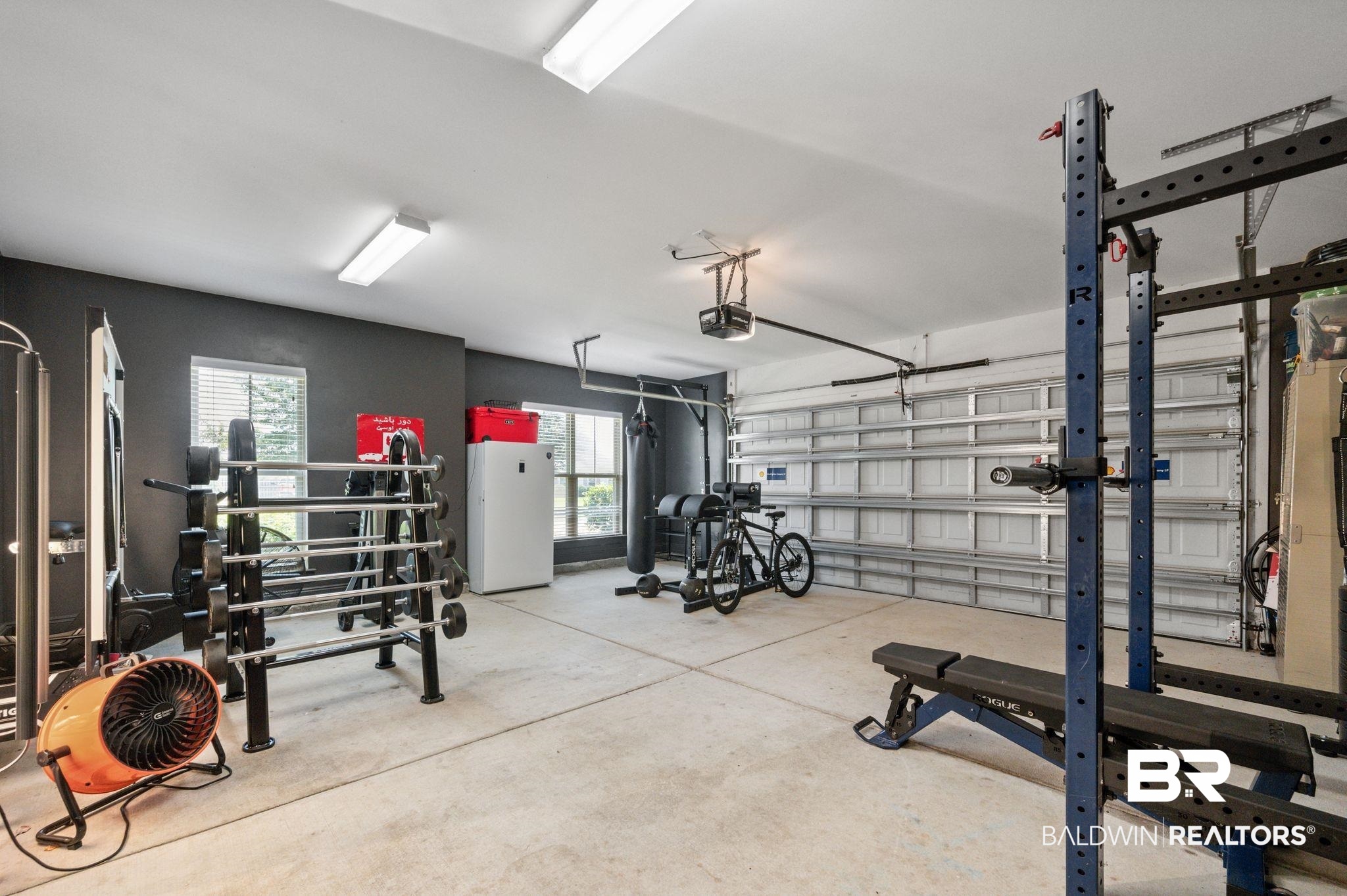 409 Fortune Drive Fairhope, AL 36532 - Photo 34 of 42 Spacious garage featuring a concrete floor, two windows with blinds, and white overhead lighting