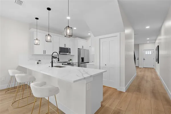 a large kitchen with granite countertop a sink a counter space and stainless steel appliances