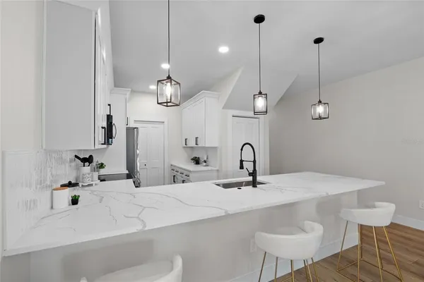 a bathroom with a sink a large mirror and a chandelier