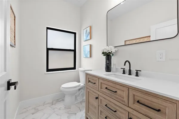 a bathroom with a granite countertop toilet sink and mirror