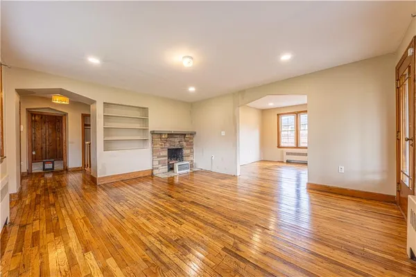 a view of empty room with wooden floor and window