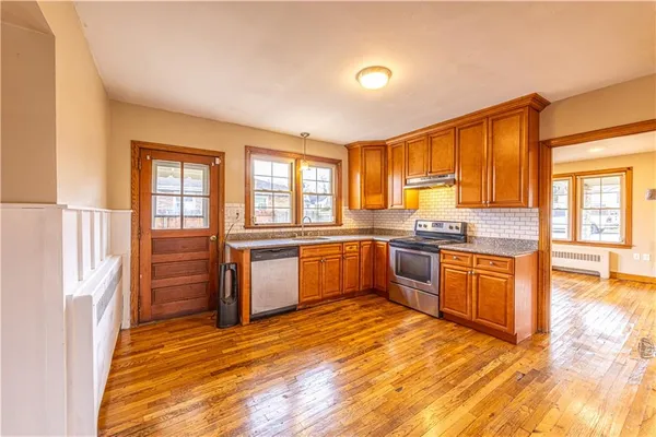 a large kitchen with stainless steel appliances granite countertop a stove a sink and a refrigerator