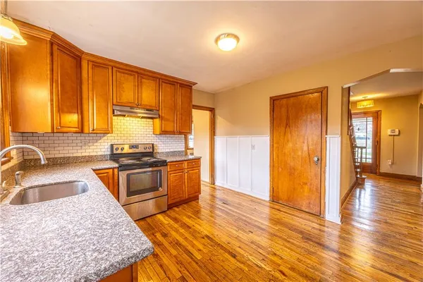 a kitchen with stainless steel appliances granite countertop a sink stove and refrigerator