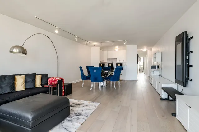 a living room with furniture and a view of kitchen