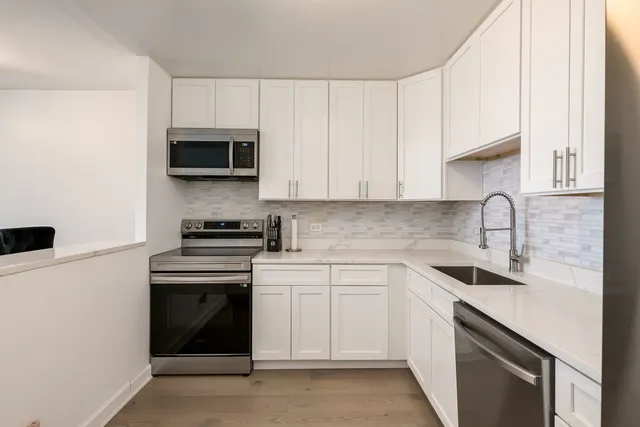 a kitchen with white cabinets and white appliances