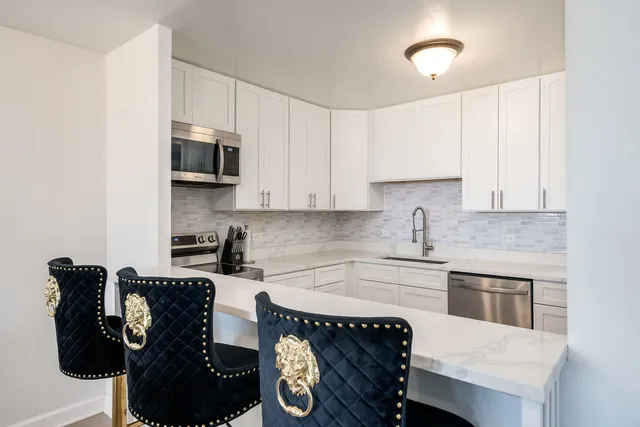 a kitchen with stainless steel appliances a stove a sink a microwave and cabinets