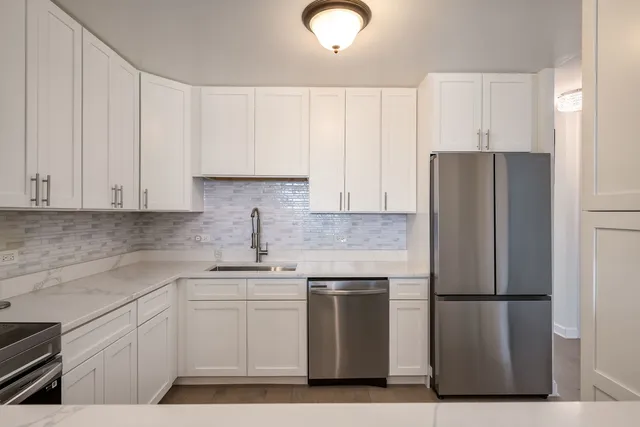 a kitchen with a refrigerator sink and cabinets