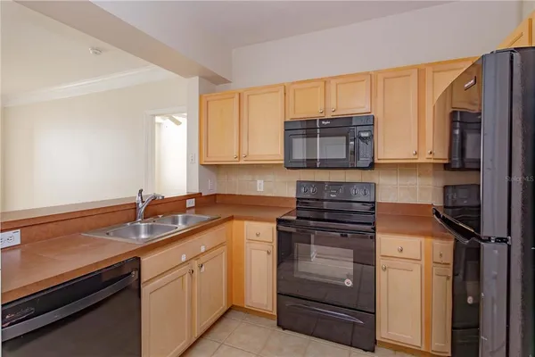 a kitchen with granite countertop a sink stove and refrigerator