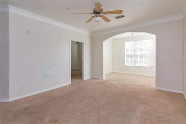 a view of a big room with windows and chandelier fan