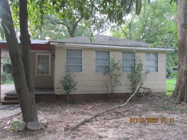 a view of a house with a tree and wooden fence