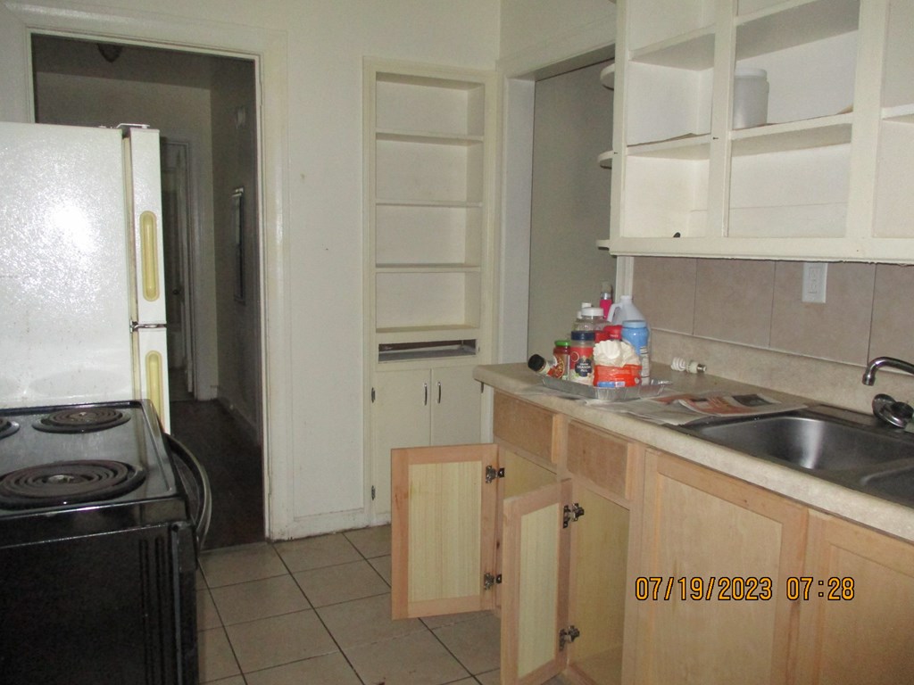 1036 Calvin Avenue Columbus, GA 31903 - Photo 6 of 23 a kitchen with granite countertop a sink stove and cabinets