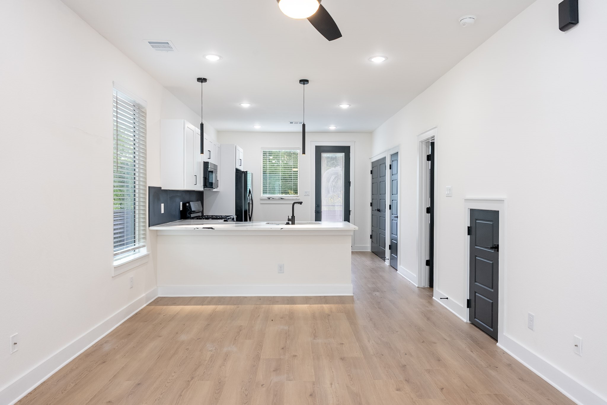 3522 Mansfield Street Houston, TX 77091 - Photo 4 of 12 1st Floor Living Room, Dining area & Kitchen w/ under-staircase storage space, powder room, walk-in pantry & Laundry. Washer & Dryer included. Contemporary finishes including quartz counters and sleek black lighting fixtures. Back porch area in every home.