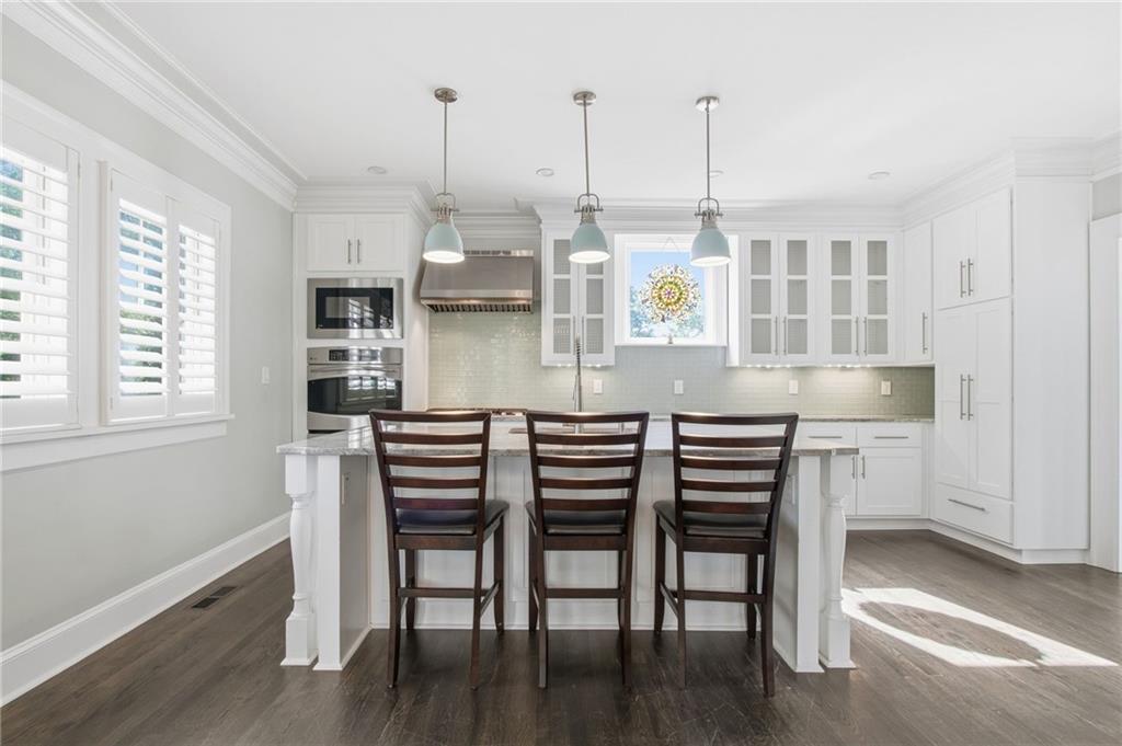 1417 Briarcliff Road Northeast Atlanta, GA 30306 - Photo 10 of 51 a kitchen with granite countertop a table chairs stove and wooden floor
