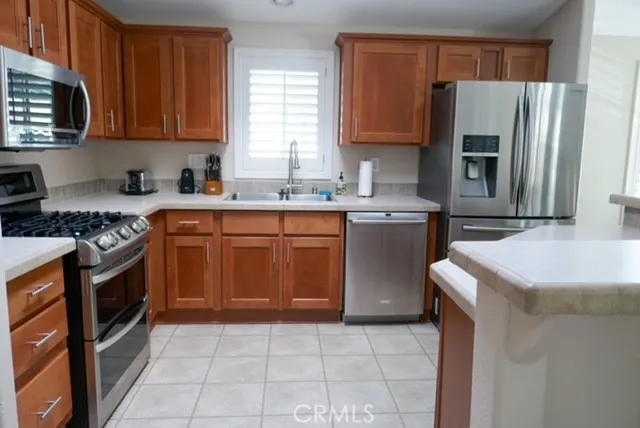 a kitchen with stainless steel appliances granite countertop a stove a sink dishwasher and a refrigerator