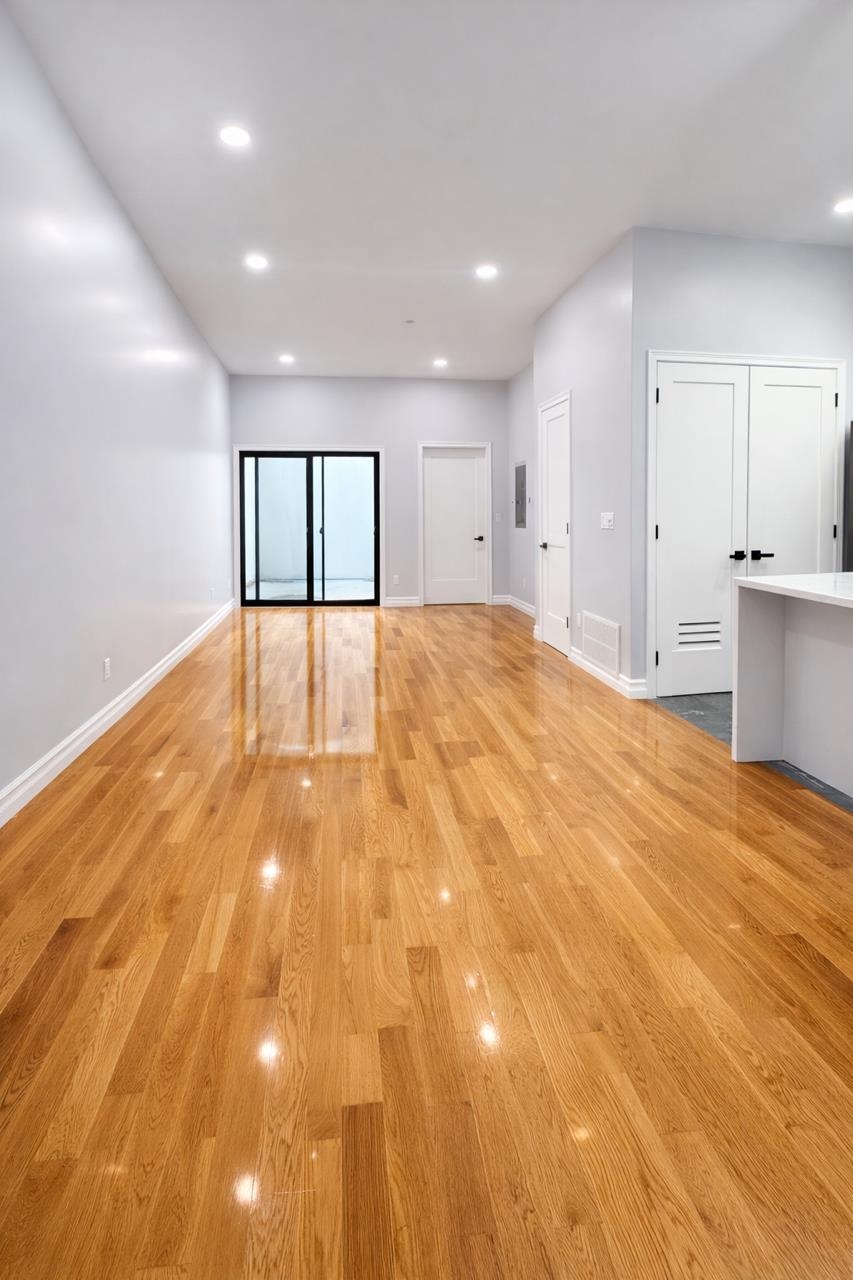 116 36th Street, Unit 2 Union City, NJ 07087 - Photo 2 of 7 a view of an empty room with window and wooden floor