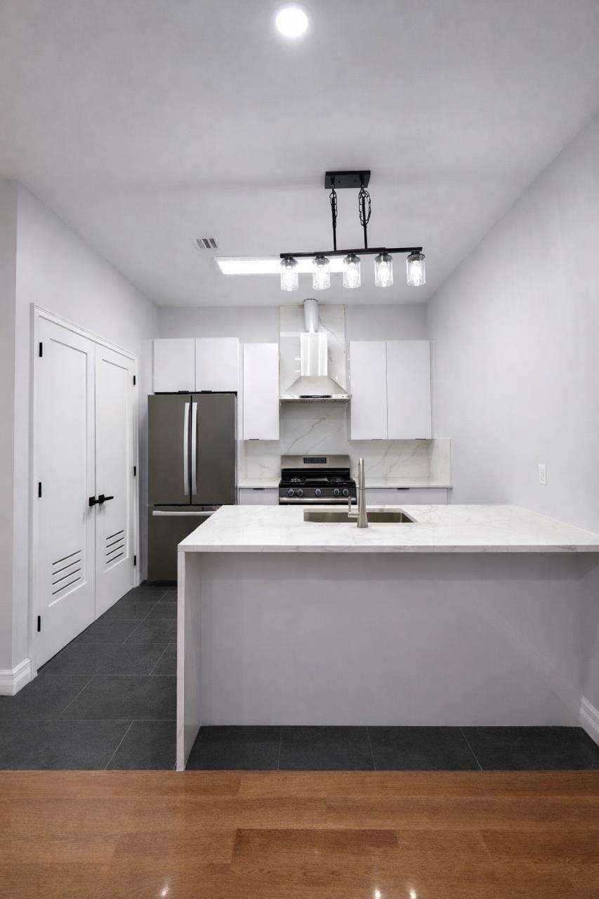 116 36th Street, Unit 2 Union City, NJ 07087 - Photo 3 of 7 a kitchen with stainless steel appliances a refrigerator and a stove top oven