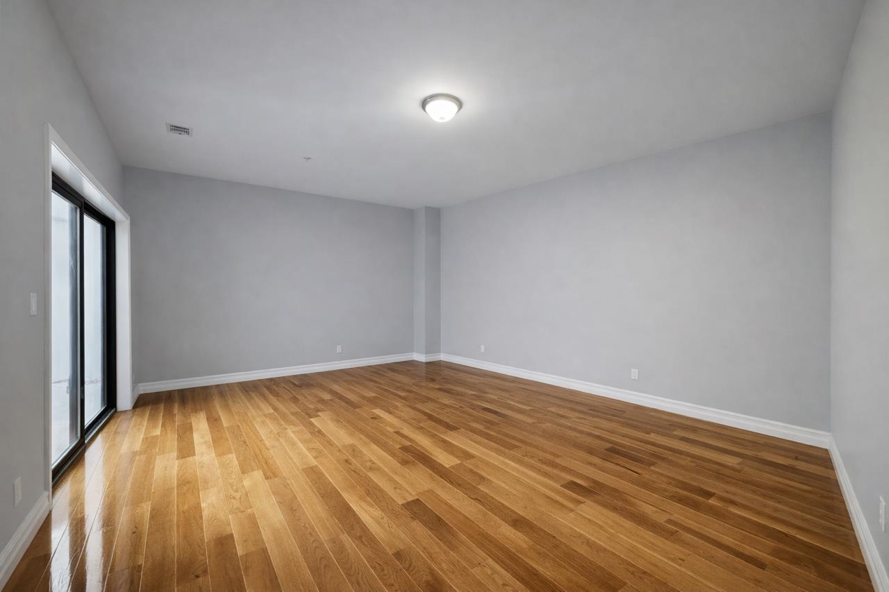 116 36th Street, Unit 2 Union City, NJ 07087 - Photo 4 of 7 a view of an empty room and wooden floor