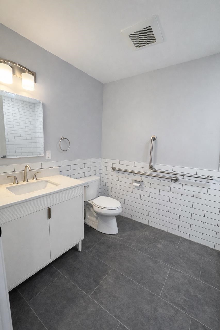 116 36th Street, Unit 2 Union City, NJ 07087 - Photo 6 of 7 a bathroom with a toilet sink and mirror