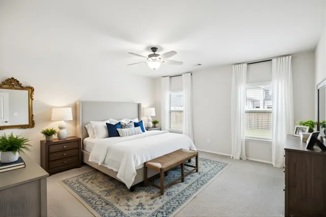 a bedroom with a bed couch and potted plant