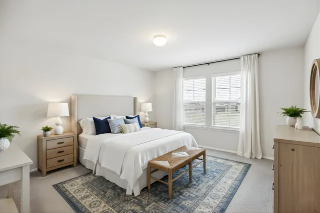 a bedroom with a bed table flowerpot and window