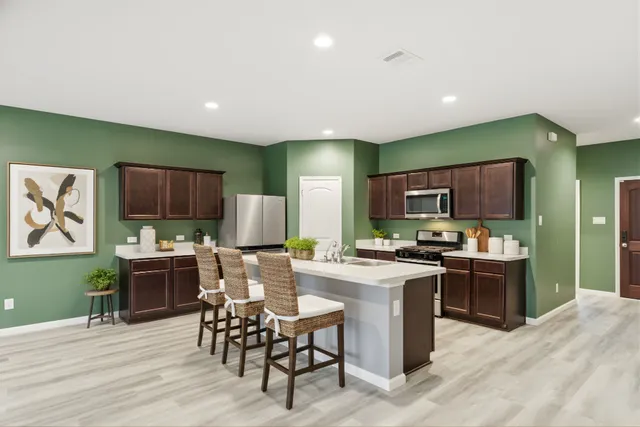 a kitchen with stainless steel appliances kitchen island granite countertop a stove top oven a sink dishwasher and a refrigerator