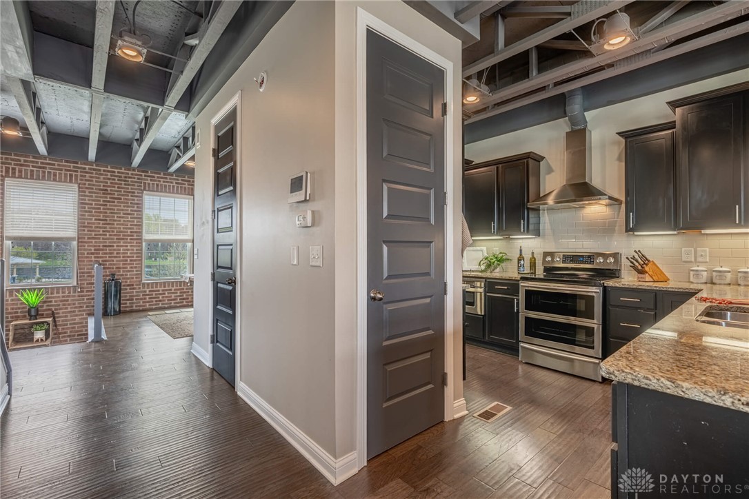 407 Brownstone Row Springboro, OH 45066 - Photo 14 of 54 This living area features rich wood flooring, exposed brick, and a functional kitchen with modern appliances.