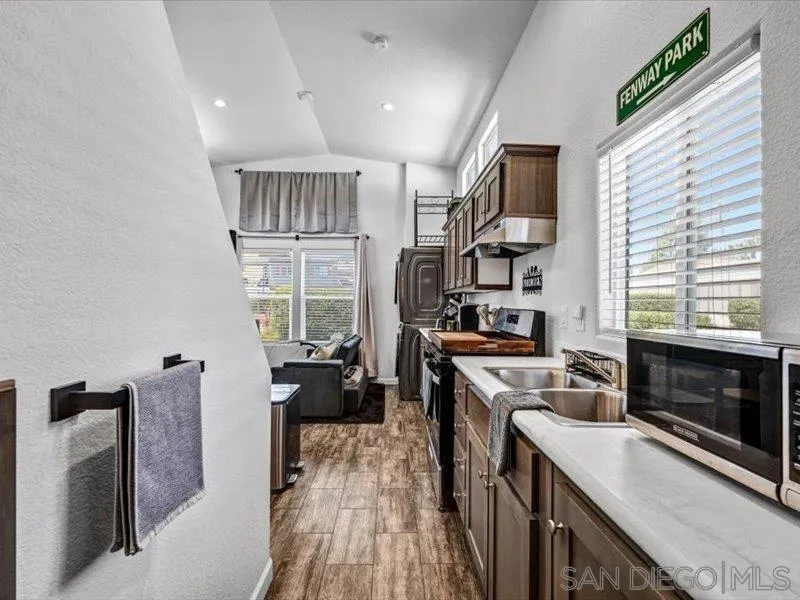 14291 Rios Canyon Road, Unit 3 El Cajon, CA 92021 - Photo 15 of 16 a kitchen with cabinets wooden floor and a fireplace
