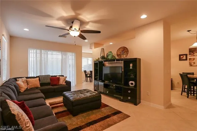 a living room with furniture a flat screen tv and a window