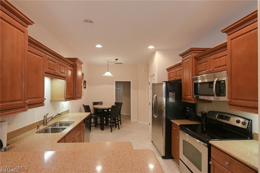 20056 Larino Loop Estero, FL 33928 - Photo 16 of 31 a kitchen with stainless steel appliances a sink a stove a refrigerator cabinets and a dining table