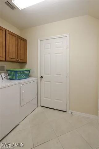a utility room with cabinets washer and dryer
