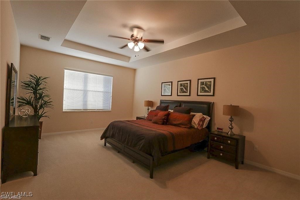 20056 Larino Loop Estero, FL 33928 - Photo 26 of 31 a bedroom with a bed and a chandelier