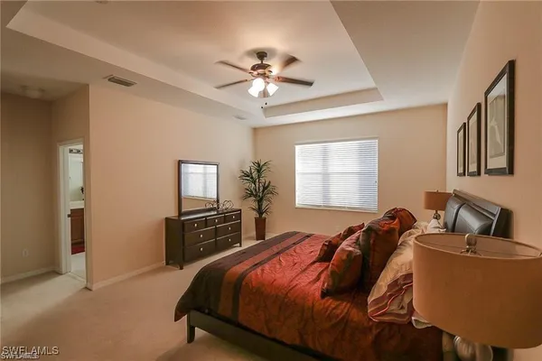 a bedroom with a bed and dresser with mirror