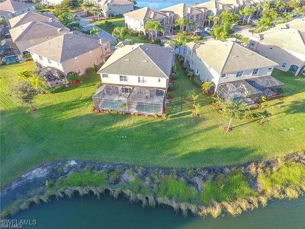 an aerial view of residential houses with outdoor space and trees