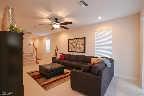 a living room with furniture and a ceiling fan