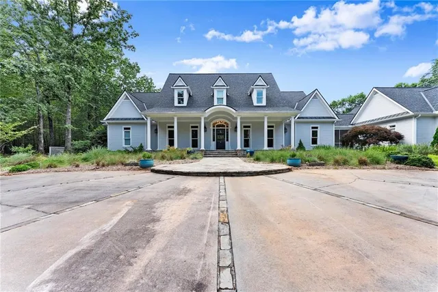 a front view of a house with a yard and potted plants