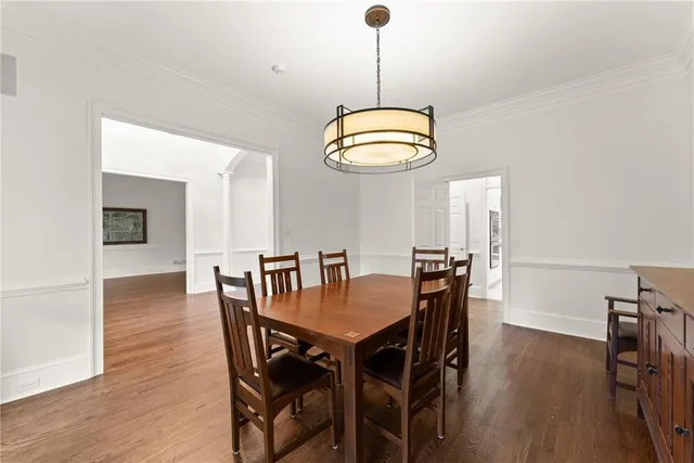 an empty room with wooden floor chandelier fan and windows