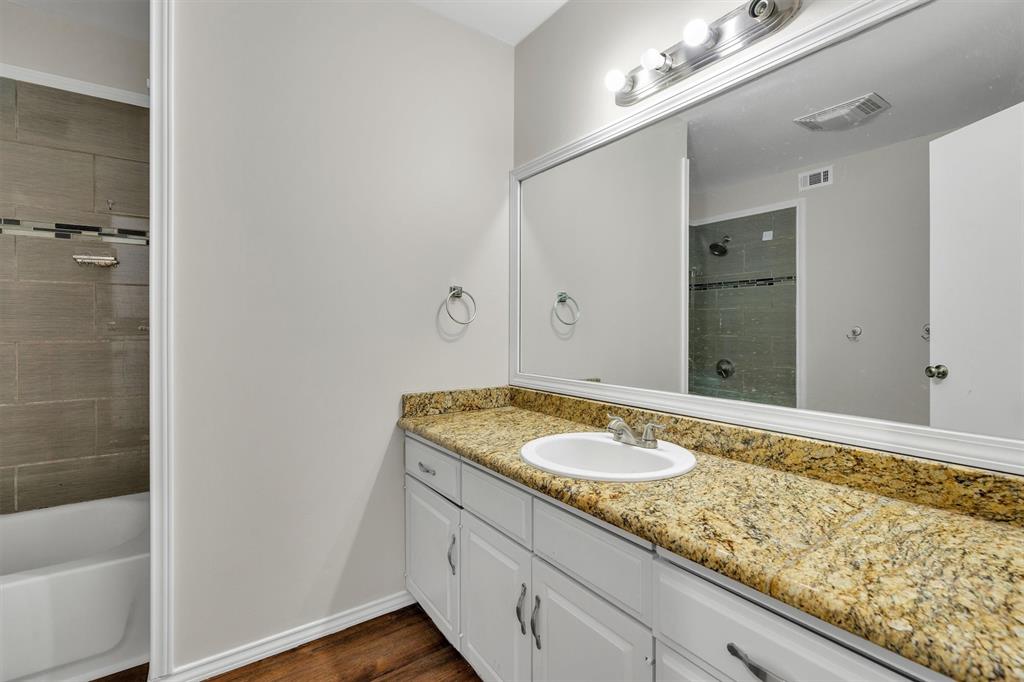 209 Mistletoe Lane Keene, TX 76059 - Photo 32 of 38 a bathroom with a granite countertop sink and a mirror