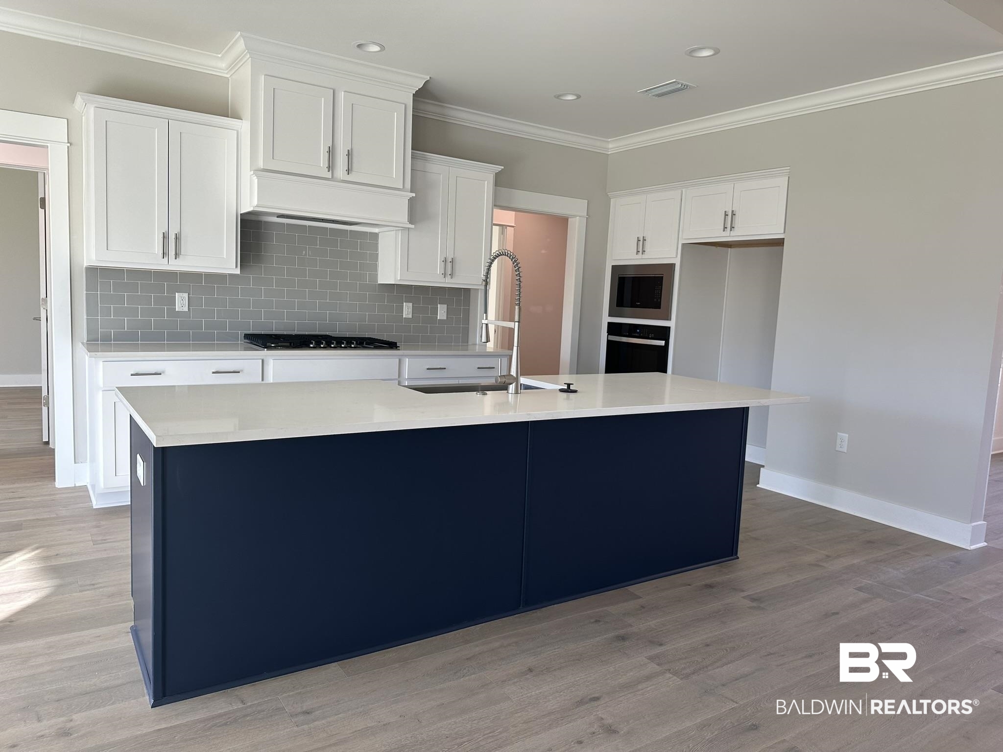 23582 Travis Stock Street, Unit 48 Foley, AL 36535 - Photo 10 of 51 Kitchen featuring sink, stainless steel appliances, an island with sink, light hardwood / wood-style floors, and white cabinets
