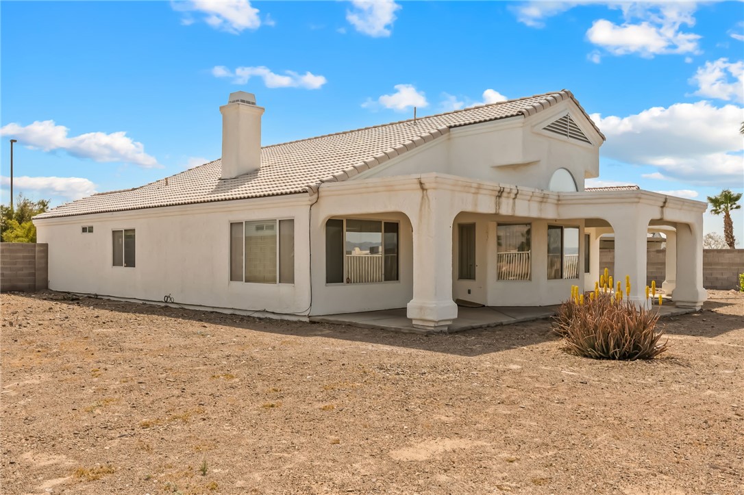 2853 Winchester Road Bullhead City, AZ 86442 - Photo 34 of 40 The property features a stucco exterior, a tiled roof, and an enclosed patio area with supporting columns