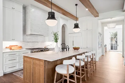 a kitchen with a dining table chairs sink and stove