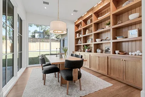 a dining room with furniture and a floor to ceiling window