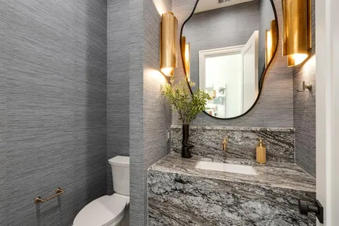 a bathroom with a toilet sink and mirror