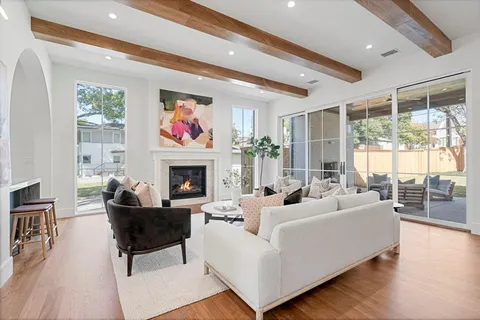 a living room with furniture large window and fireplace