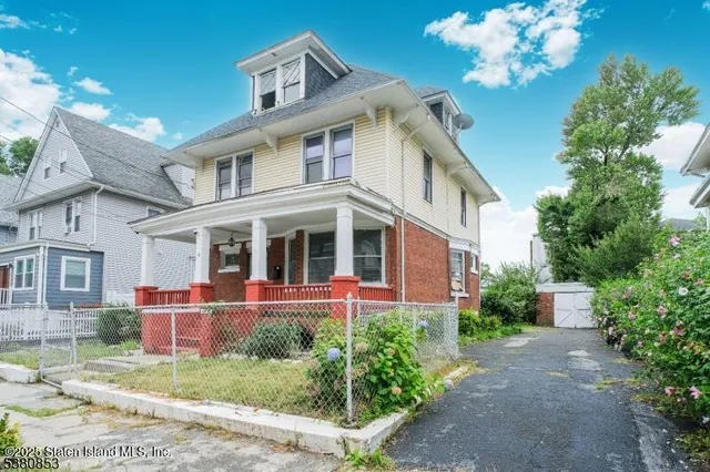 a front view of a house with a yard and trees