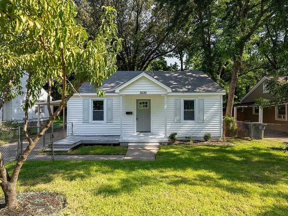 a front view of a house with a yard and trees