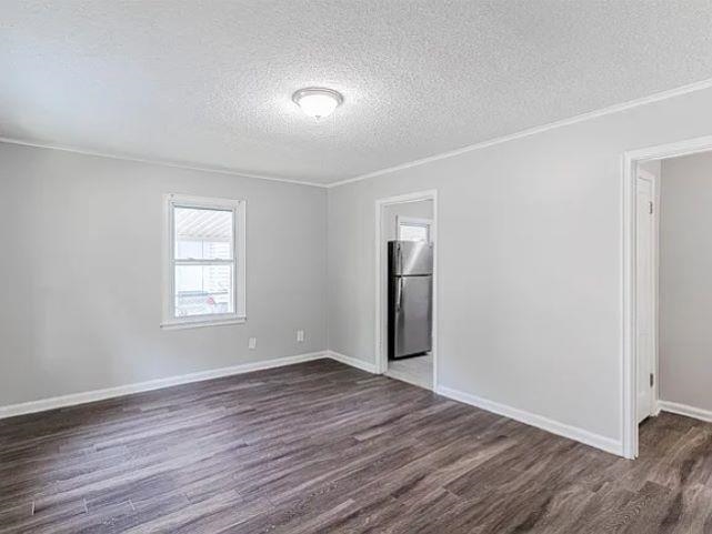 3530 Wilshire Road Memphis, TN 38111 - Photo 2 of 12 an empty room with wooden floor and windows