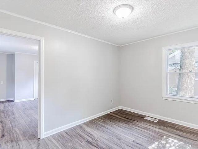 3530 Wilshire Road Memphis, TN 38111 - Photo 3 of 12 an empty room with wooden floor and windows