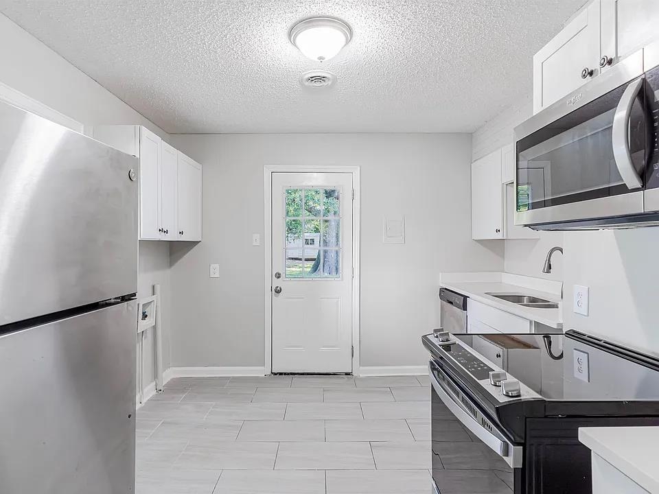 3530 Wilshire Road Memphis, TN 38111 - Photo 4 of 12 a kitchen with stainless steel appliances granite countertop a stove a refrigerator and a microwave