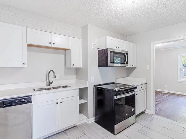 3530 Wilshire Road Memphis, TN 38111 - Photo 5 of 12 a kitchen with cabinets stainless steel appliances and wooden floor